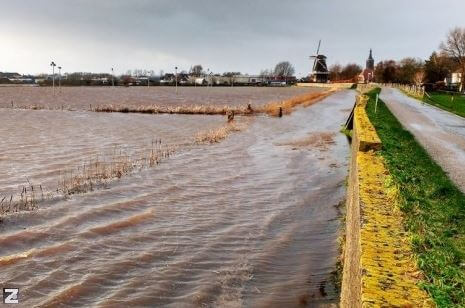 Stenendijk met land onder water